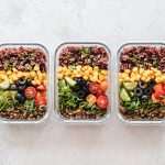 Trois boites de repas en verre garnies de riz, mais, concombre, tomates, olives et lentilles, pour transformer des restes en repas equilibre.